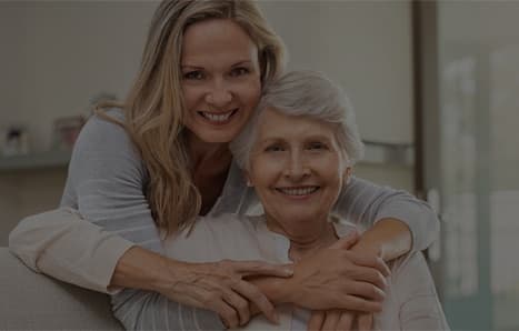A daughter embracing her elderly mother at home